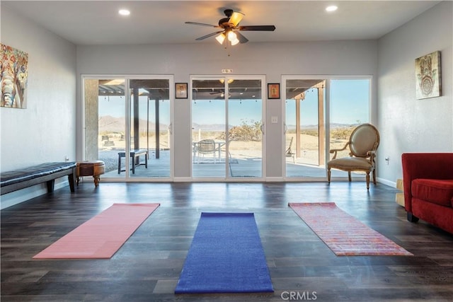 workout area with dark hardwood / wood-style flooring and ceiling fan