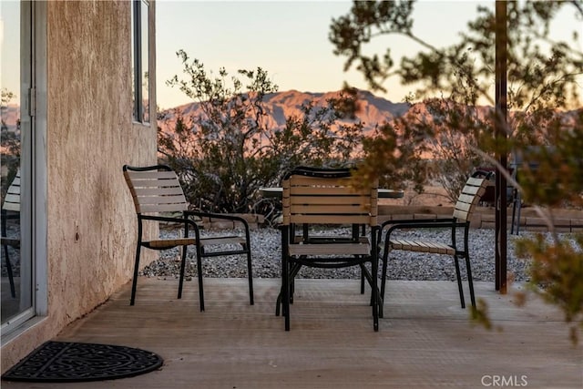 balcony at dusk with a deck with mountain view