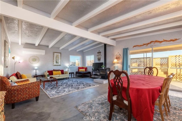 dining room with lofted ceiling with beams, a wood stove, a wealth of natural light, and concrete floors