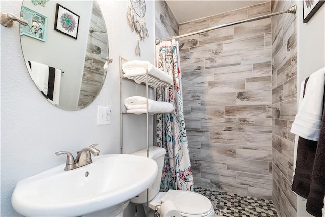 bathroom with a shower with curtain, toilet, and sink