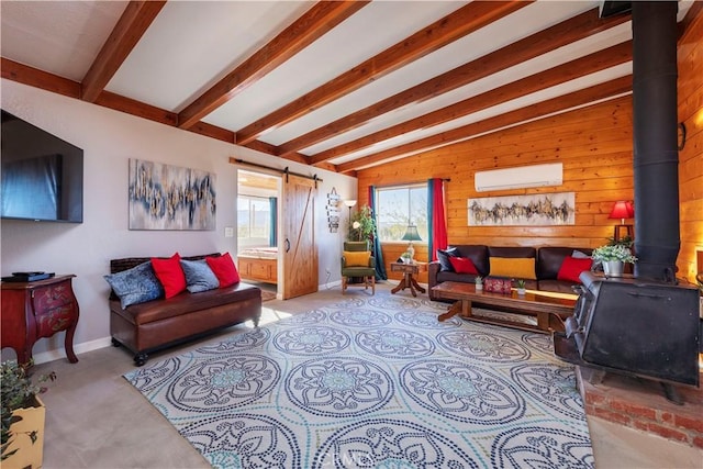 living room with a wood stove, a wall mounted air conditioner, lofted ceiling with beams, a barn door, and wood walls