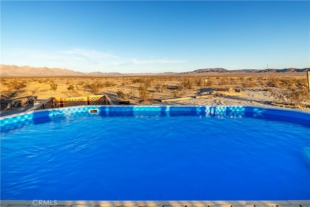 view of swimming pool with a mountain view