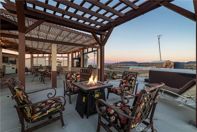 patio terrace at dusk with an outdoor fire pit and a pergola