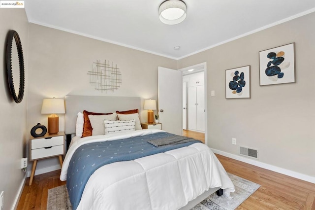 bedroom featuring crown molding and wood-type flooring