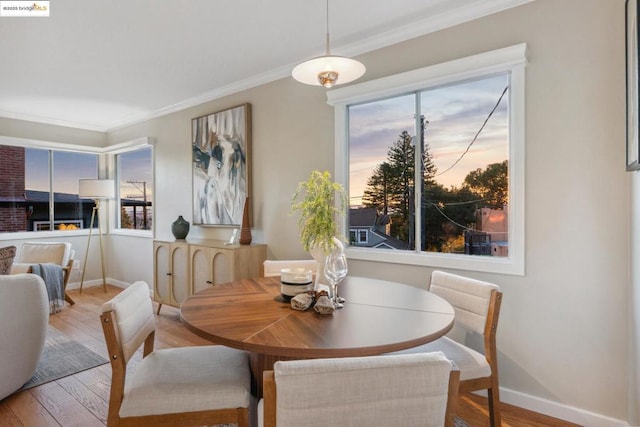 dining area with crown molding and light hardwood / wood-style floors