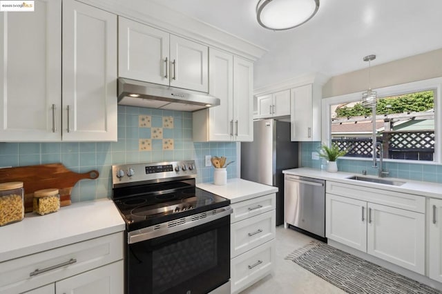 kitchen featuring appliances with stainless steel finishes, decorative light fixtures, tasteful backsplash, white cabinetry, and sink