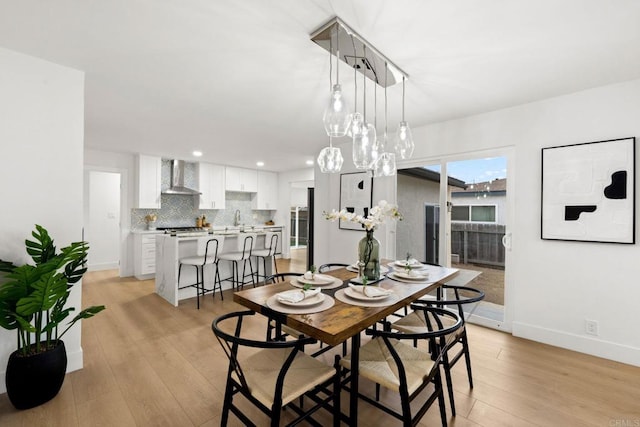 dining space with sink and light wood-type flooring