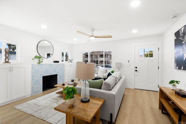 living room with ceiling fan and light hardwood / wood-style flooring