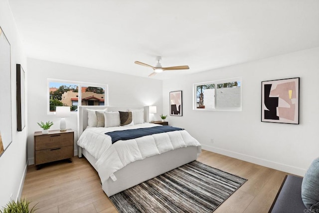 bedroom featuring multiple windows, ceiling fan, and light wood-type flooring