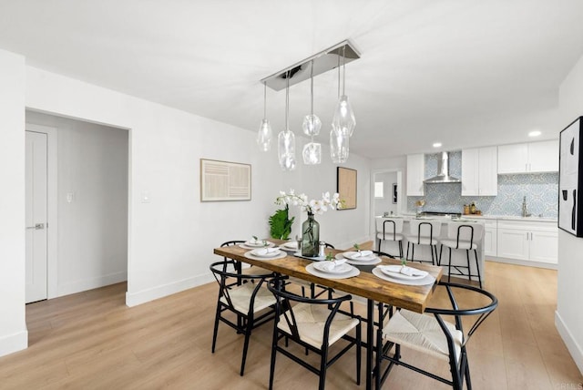 dining space featuring sink and light hardwood / wood-style flooring