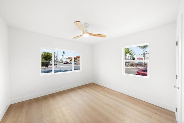 empty room with ceiling fan and light hardwood / wood-style flooring