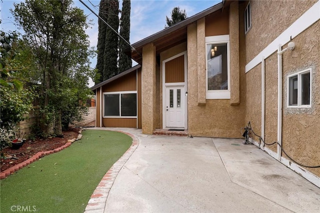 view of exterior entry with a patio