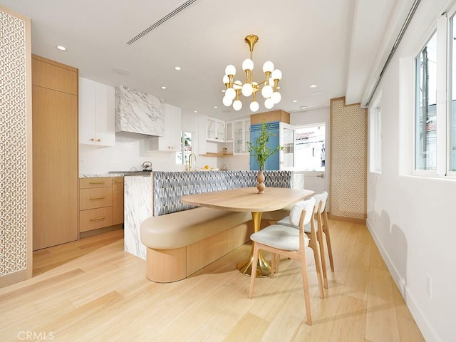 dining room with a chandelier and light wood-type flooring