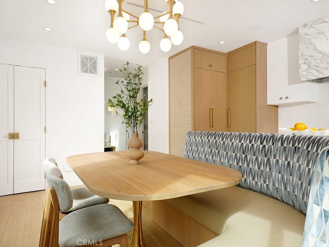 dining area featuring a notable chandelier and light hardwood / wood-style flooring