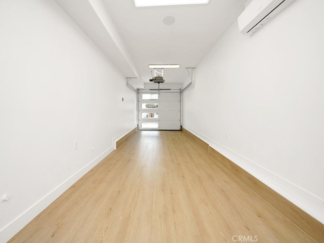 spare room featuring a wall mounted air conditioner and light hardwood / wood-style flooring