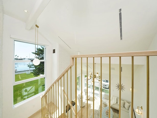 stairway featuring lofted ceiling with beams