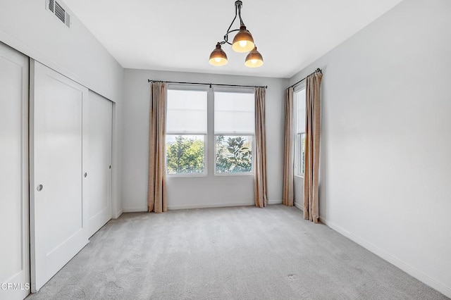 unfurnished bedroom featuring light carpet and a closet