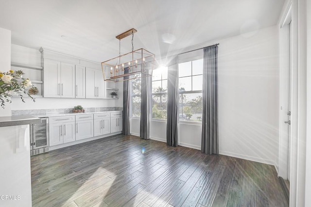 kitchen featuring pendant lighting, dark wood-type flooring, wine cooler, and white cabinets