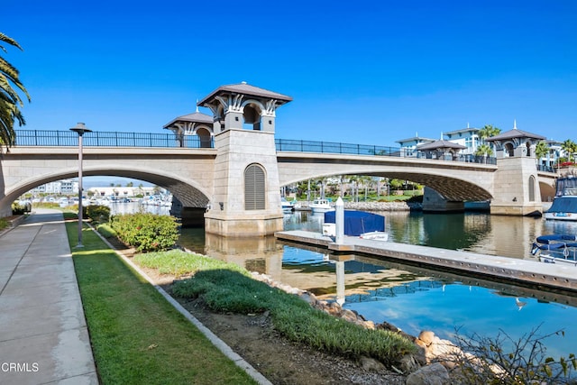 surrounding community with a boat dock and a water view