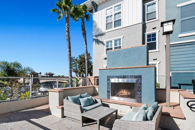 view of patio / terrace with an outdoor living space with a fireplace