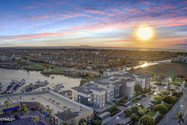 aerial view at dusk featuring a water view