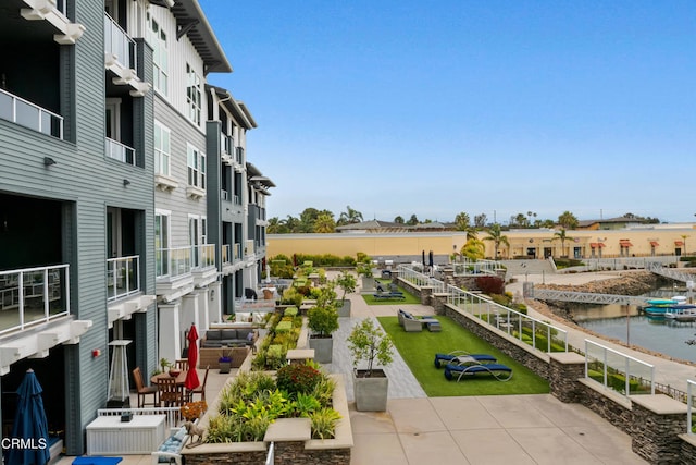 view of property's community with a water view and a patio area