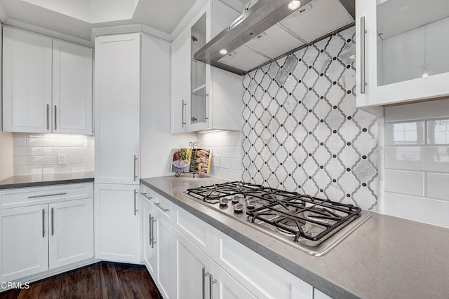 kitchen with white cabinetry, backsplash, stainless steel gas cooktop, dark wood-type flooring, and wall chimney exhaust hood