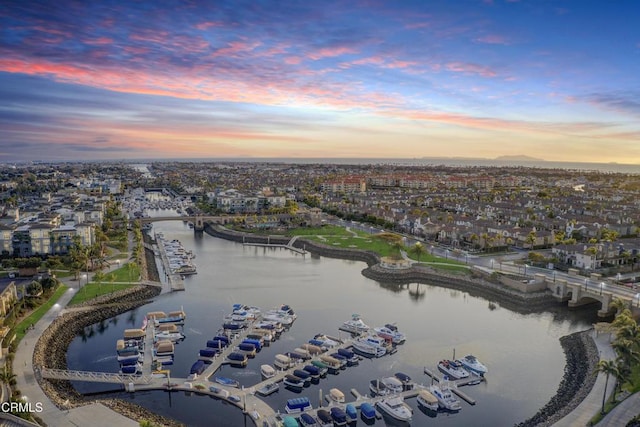 aerial view at dusk featuring a water view