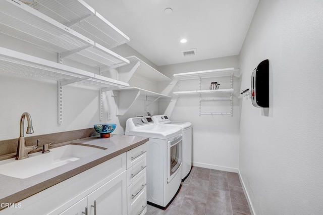 washroom featuring cabinets, independent washer and dryer, and sink