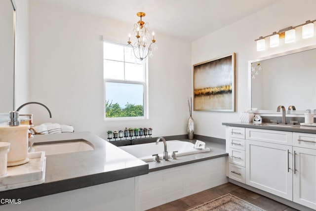 full bathroom with a sink, a garden tub, two vanities, and a chandelier