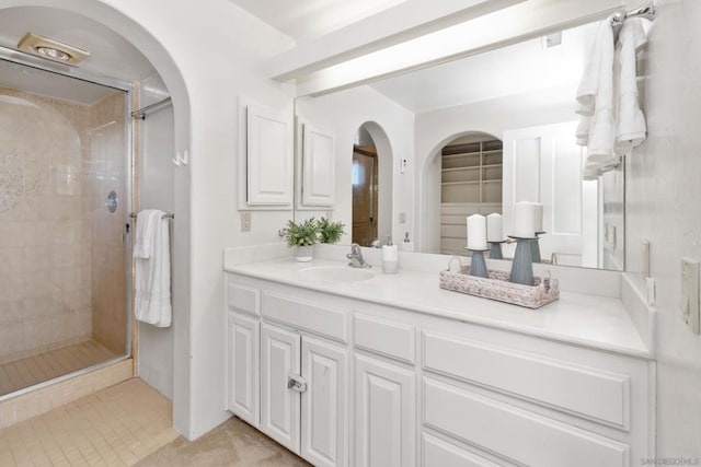 bathroom featuring vanity and a shower with door