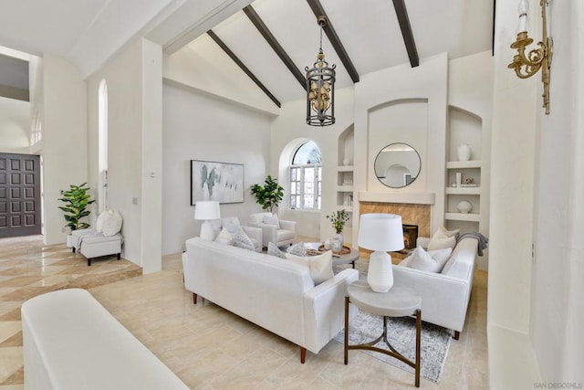 living room featuring built in shelves, a fireplace, high vaulted ceiling, and beam ceiling