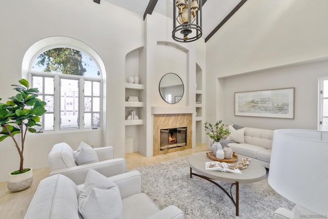 living room with built in shelves, a fireplace, and a high ceiling