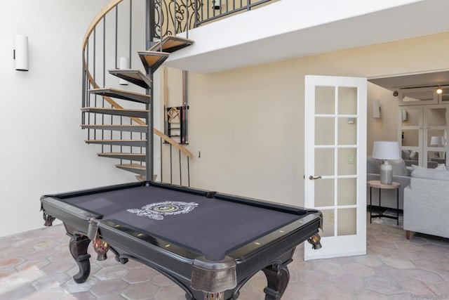 game room with a towering ceiling, pool table, and french doors