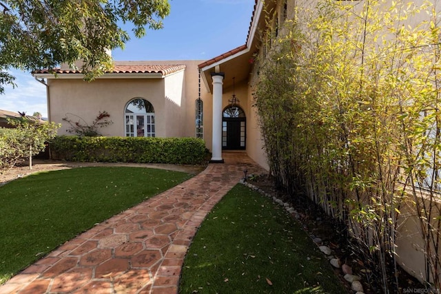 entrance to property featuring a lawn