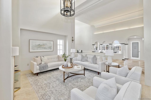 living room with a towering ceiling and beam ceiling