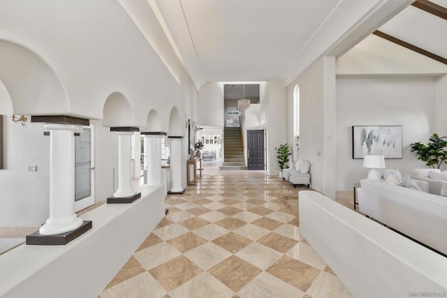 interior space with plenty of natural light, a high ceiling, and ornate columns