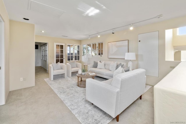 carpeted living room featuring track lighting