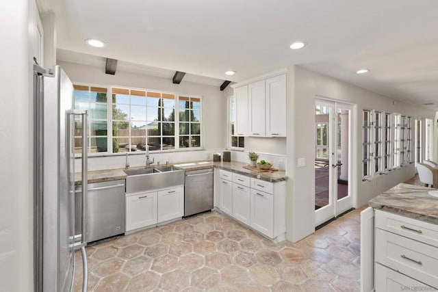 kitchen with white cabinetry, sink, stainless steel appliances, and stone countertops