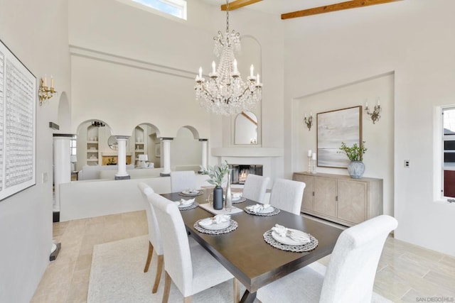 dining area with an inviting chandelier, light tile patterned flooring, and a high ceiling