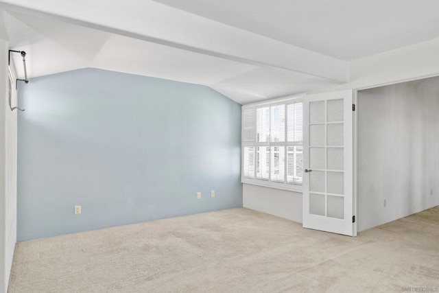 empty room featuring vaulted ceiling and light carpet