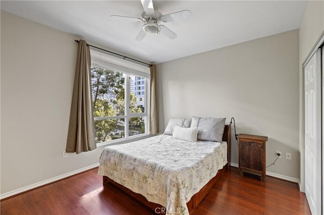 bedroom with ceiling fan, dark hardwood / wood-style flooring, and a closet