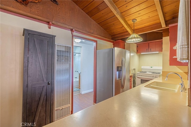 kitchen featuring sink, vaulted ceiling with beams, stainless steel refrigerator with ice dispenser, white range with gas cooktop, and decorative light fixtures