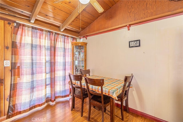 dining area featuring hardwood / wood-style flooring, vaulted ceiling with beams, and wood ceiling