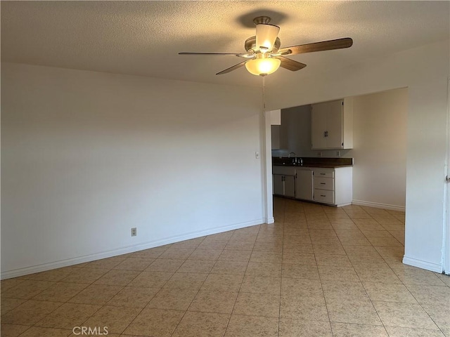 spare room with ceiling fan, sink, and a textured ceiling