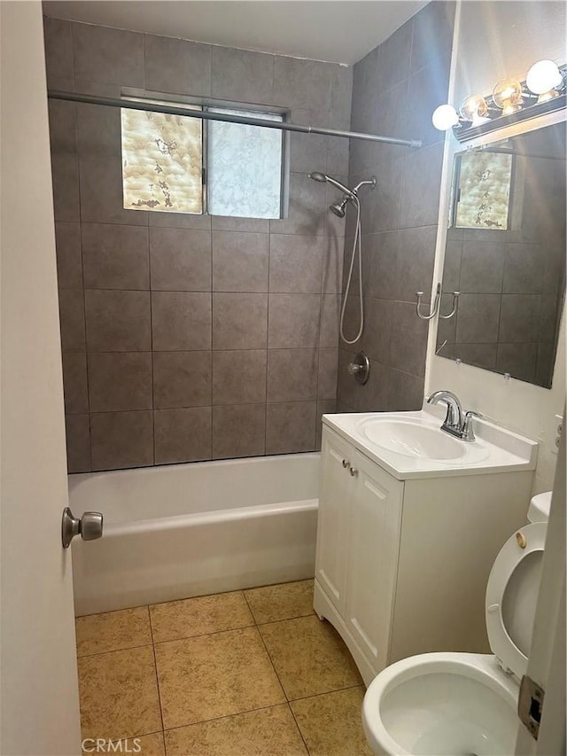 full bathroom featuring tile patterned floors, toilet, tiled shower / bath combo, and vanity