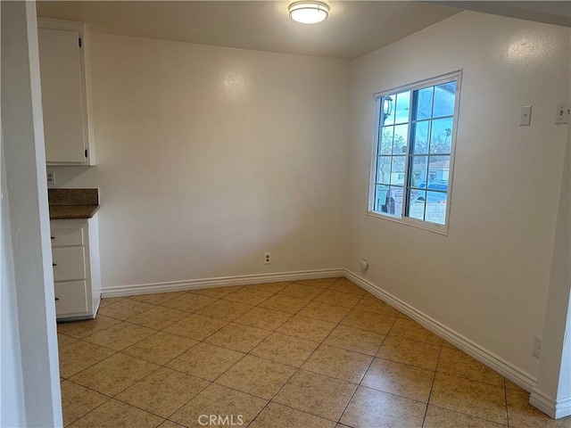 unfurnished dining area with light tile patterned flooring