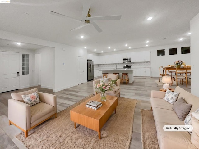 living room featuring ceiling fan and light hardwood / wood-style floors