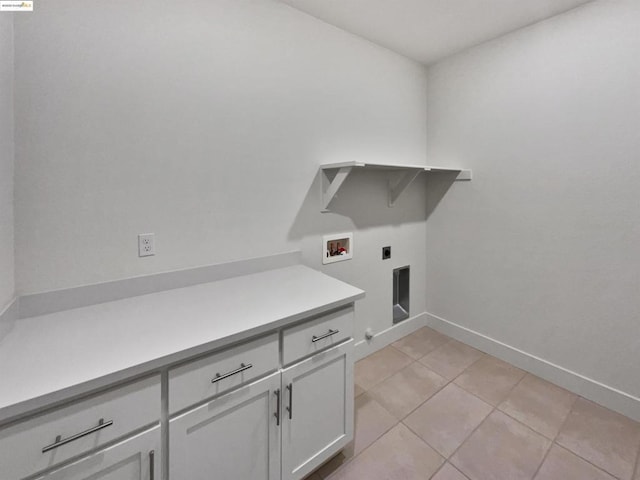 laundry room with cabinets, hookup for a washing machine, hookup for an electric dryer, and light tile patterned flooring