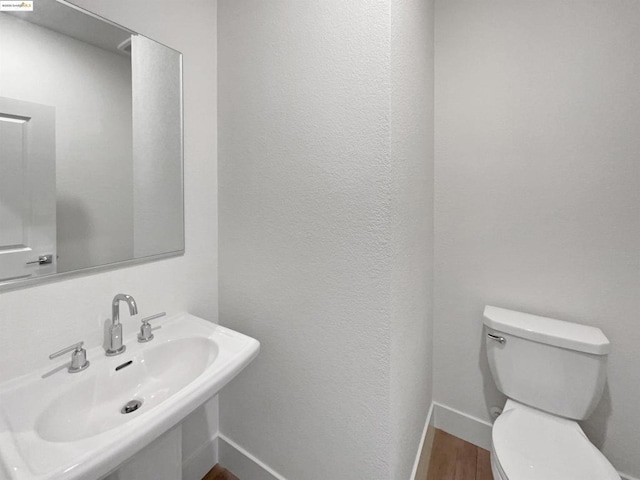 bathroom with hardwood / wood-style flooring, sink, and toilet